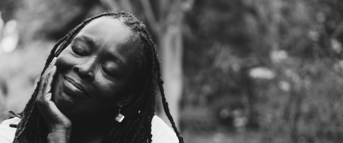 Black and white image of a woman with her eyes closed and smiling