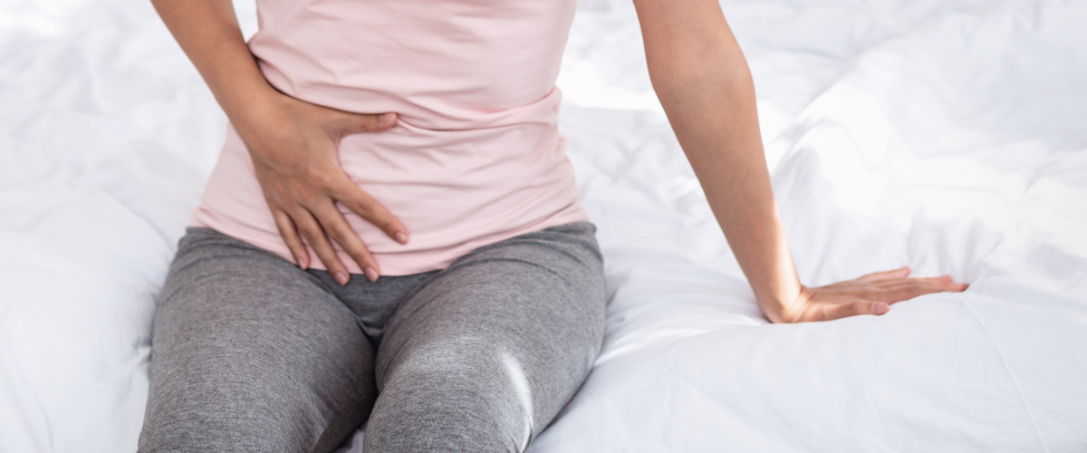 Woman holding her abdomen.