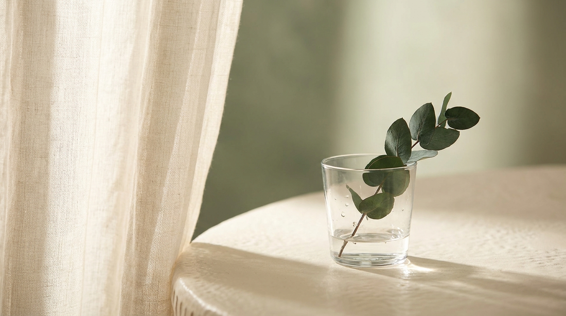 Soft morning light breaking through a sheer curtain onto a cream surface, hopeful clearing mood.